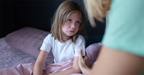 A young girl in bed with pain.