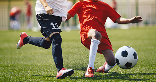 Youth soccer player landing hard on ankle and knee.